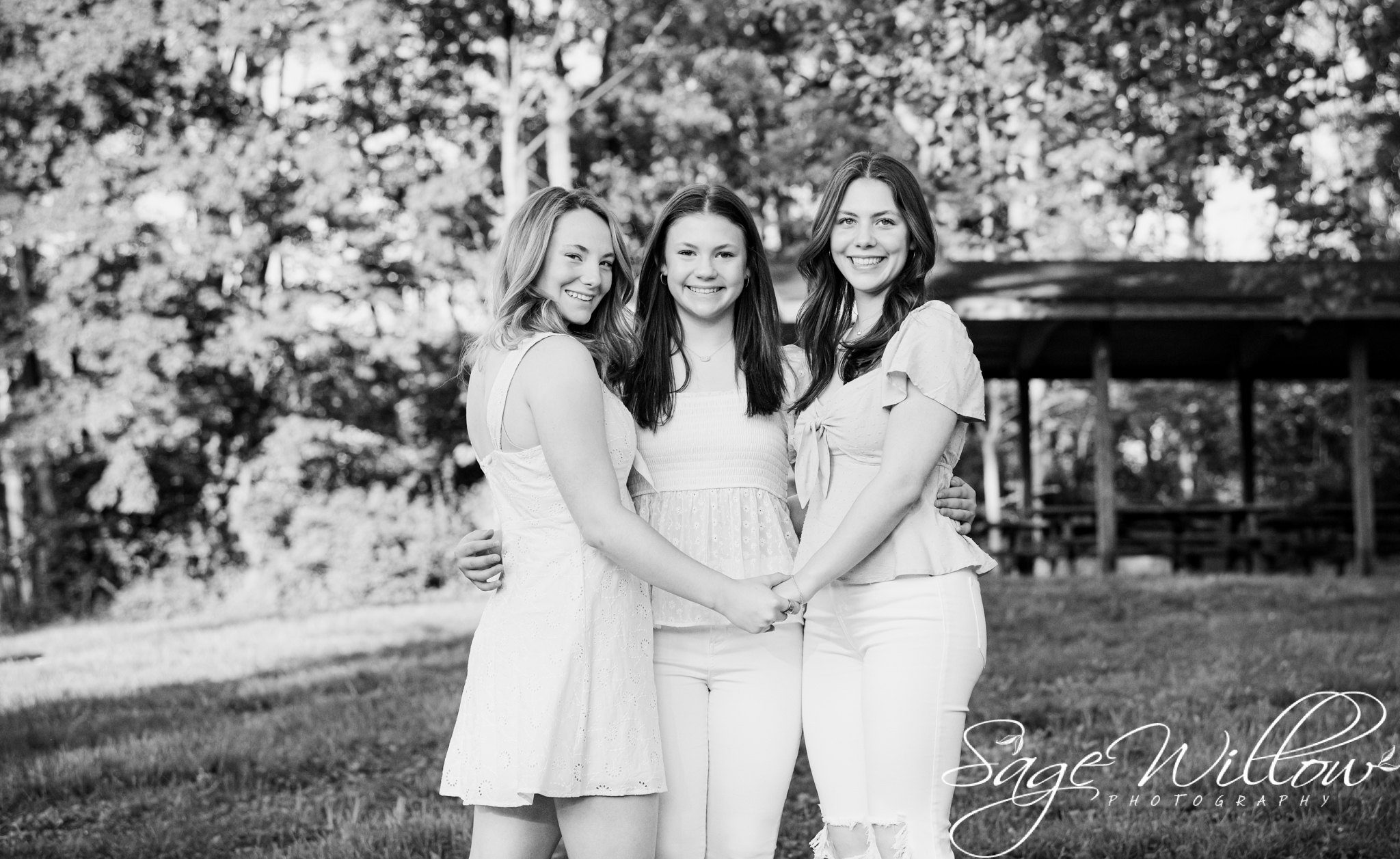 black and white photo of three sisters holding hands