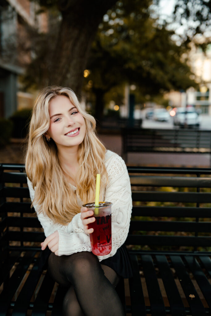 high school senior sitting on bench drinking tea during senior session