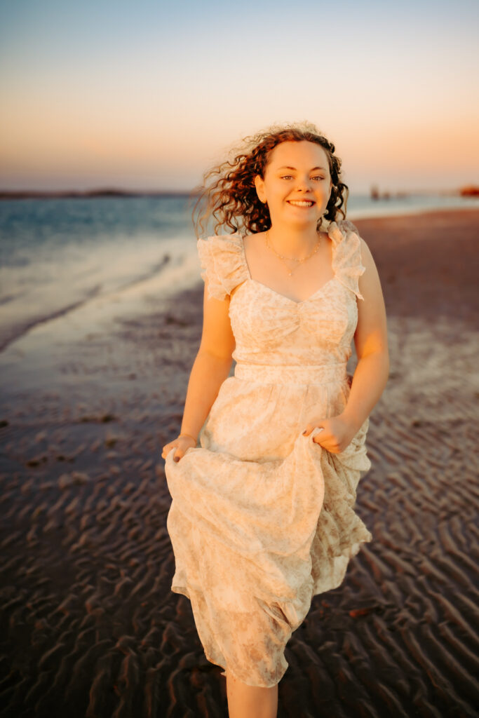 color photo of a girl running along a beach at sunset at Topsail Island, NC