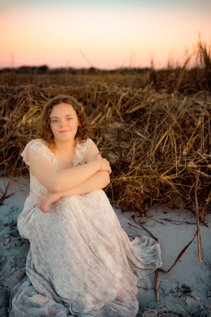color photo of girl sitting on a beach at sunset at Topsail Island, NC