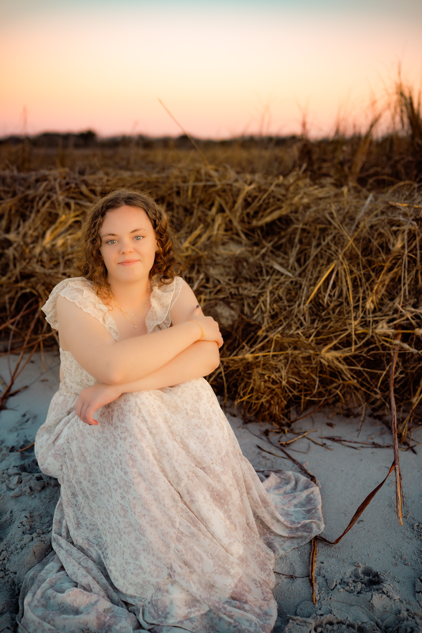 color photo of a girl sitting on the beach at sunset at Topsail Island, NC