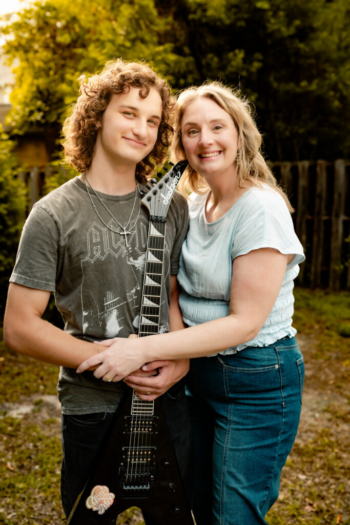 color photo of a mother and her son with his guitar