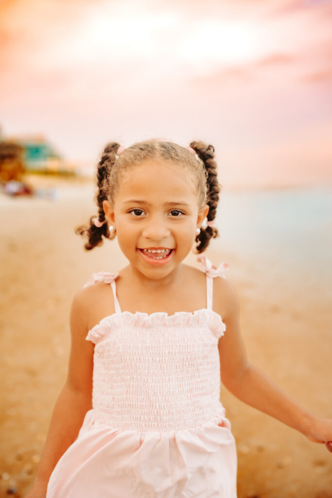 Color photo of granddaughter laughing and playing on the beach.