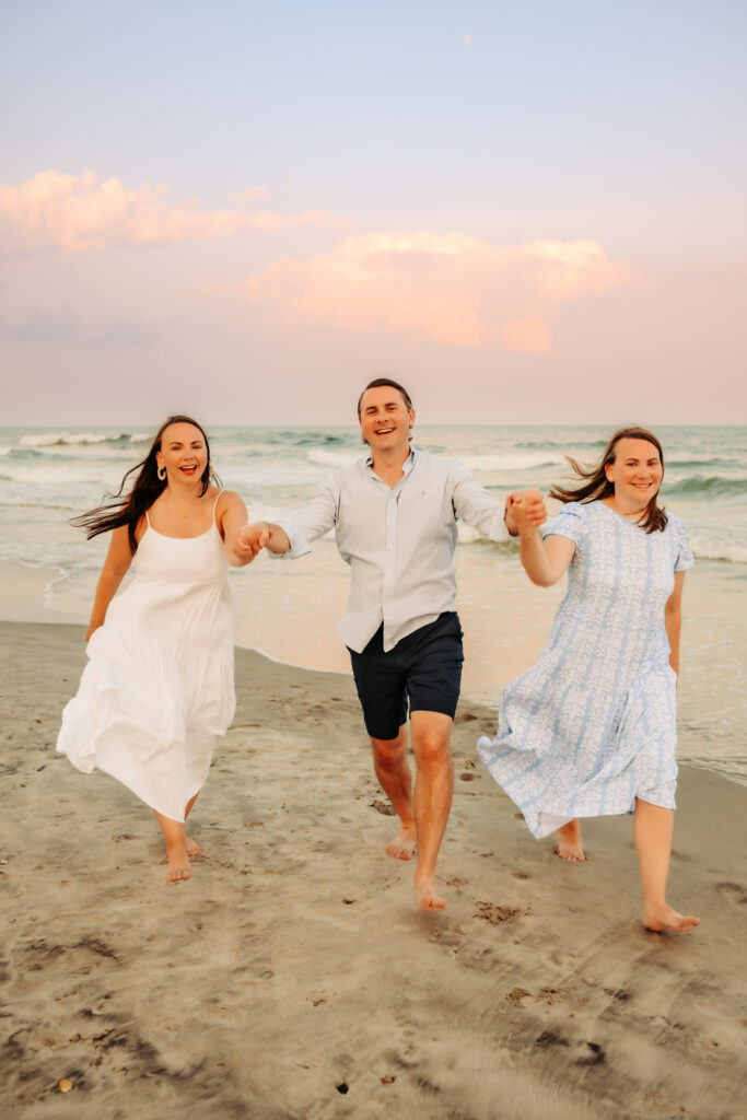color photo of siblings running on beach