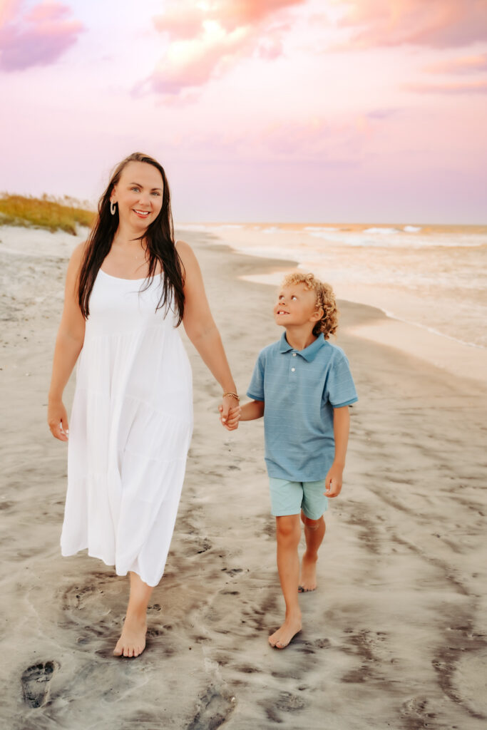 color photo of mom and son walking on the beach