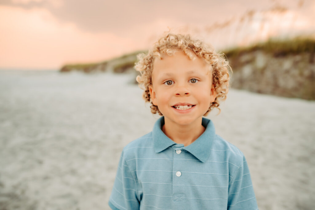 color photo of boy standing on the beach