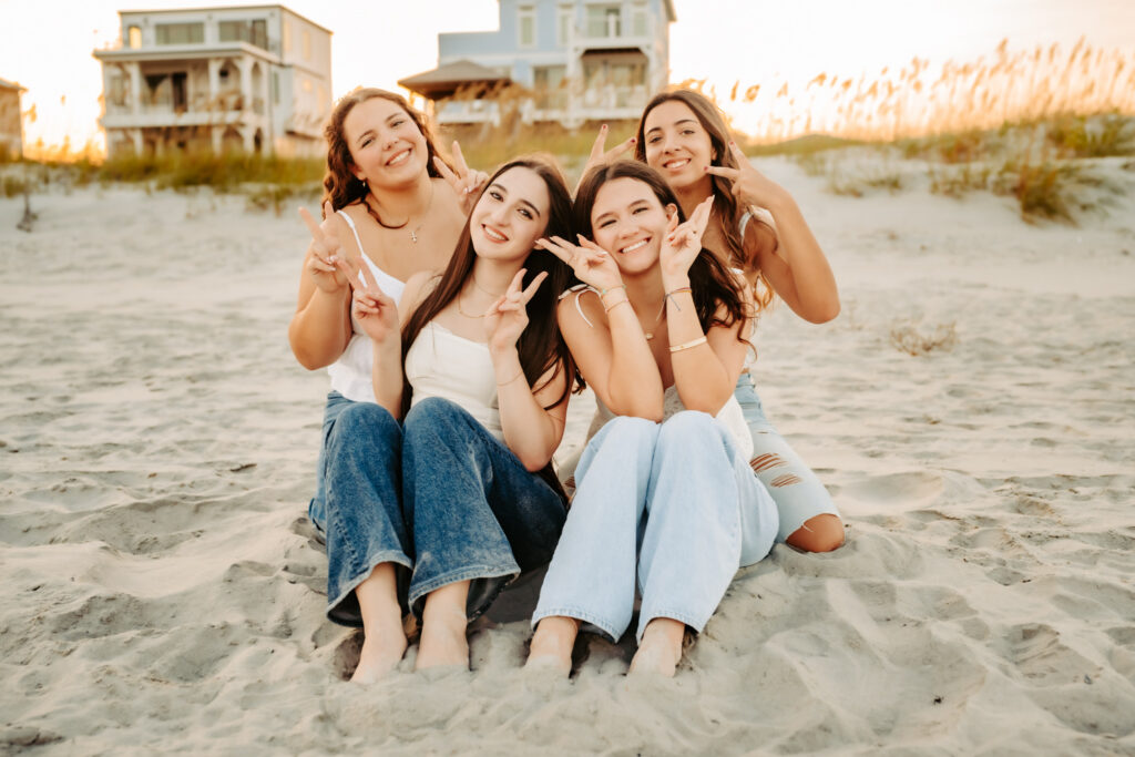 four girlfriends sitting together on the beach having fun