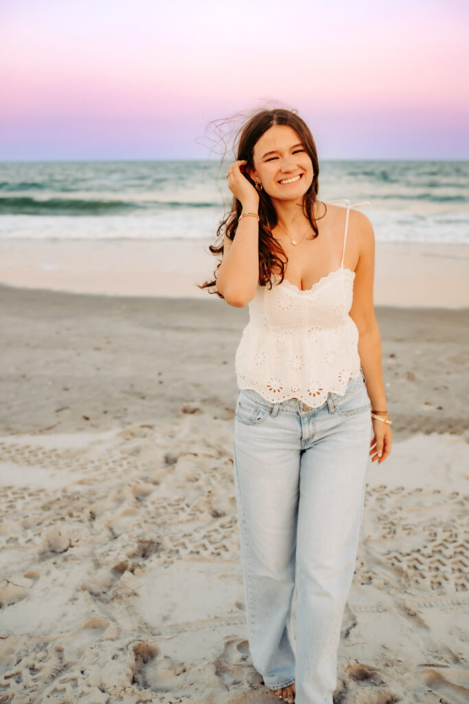 One girl walking on the beach smiling