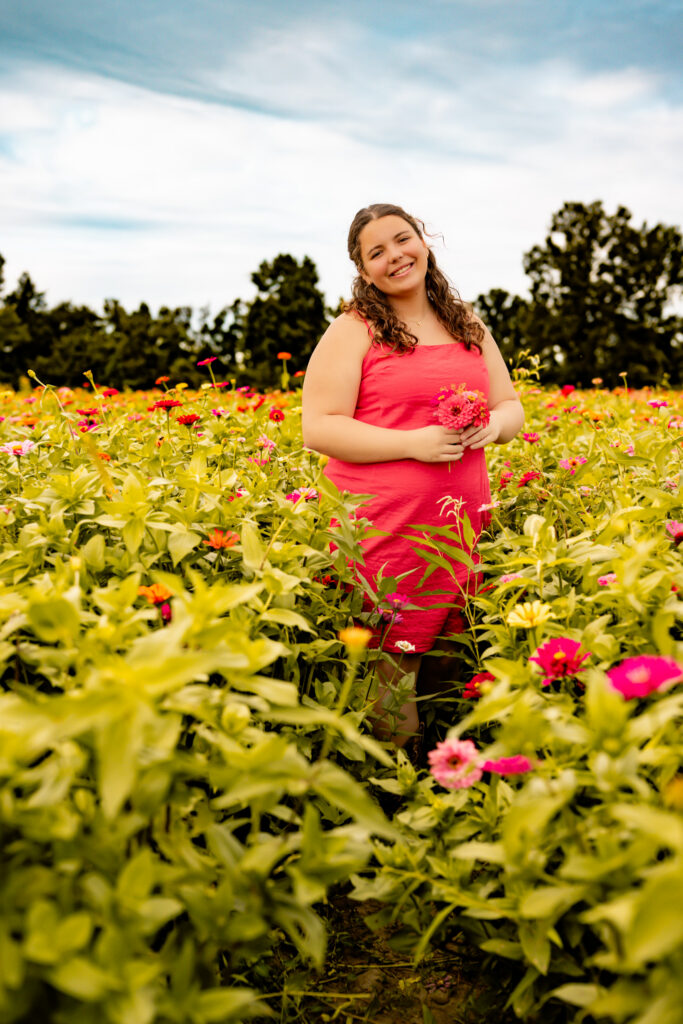 high school senior girl walking in a flower field